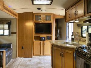an rv kitchen with a sink and a tv at H - Poop Deck in Fort Bragg