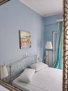 1 dormitorio con 1 cama blanca y paredes azules en Morfi, en Lefkada