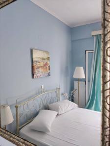 a bedroom with a white bed with blue walls at Morfi in Lefkada Town