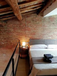 um quarto com uma cama e uma parede de tijolos em Mazi Apartments Penthouse em Badalona