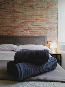 um quarto com uma cama com uma parede de tijolos em Mazi Apartments Penthouse em Badalona