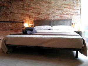 a bedroom with a large bed with a brick wall at Mazi Apartments Penthouse in Badalona