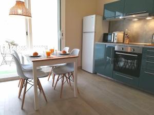 een keuken met een tafel en stoelen en een koelkast bij Mazi Apartments Penthouse in Badalona