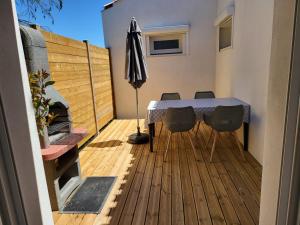 un patio con mesa y sillas en una terraza en ESCALE OCEAN A 800 m DE LA PLAGE en Notre-Dame-de-Monts