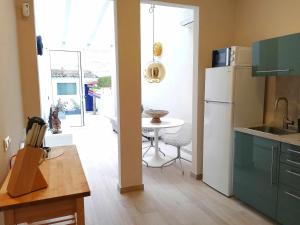 a kitchen with a white refrigerator and a table at Mazi Apartments Chic in Badalona