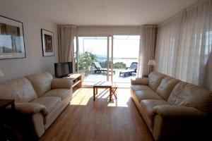 a living room with a couch and a table and a television at Apartamentos Siglo XXI - Marabu in Sant Feliu de Guíxols