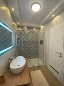 een badkamer met een witte wastafel en een douche bij Apartment Jakovcevic 3 in Zadar