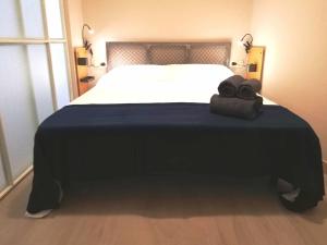 1 dormitorio con 1 cama grande con manta azul en Mazi Apartments Chic, en Badalona
