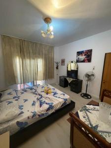 Guesthouse NEO في تيرانا: غرفة نوم بسرير ومروحة سقف