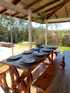uma mesa de madeira com pratos no pátio em Cabana Guimarães em Rancho Queimado