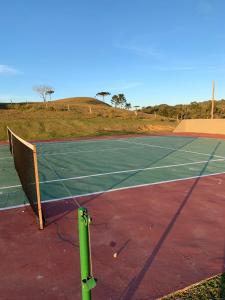 a tennis court with a net on top of it at Cabana Guimarães in Rancho Queimado