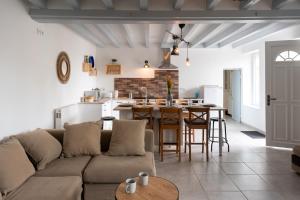 een woonkamer en een keuken met een bank en een tafel bij CABANA & LES PORTES DE LA FORÊT D' ORLÉANS in Nevoy
