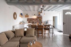 a living room and kitchen with a couch and a table at CABANA & LES PORTES DE LA FORÊT D' ORLÉANS in Nevoy