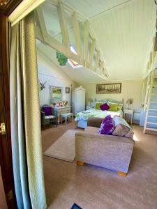 - une chambre avec un lit et un canapé dans l'établissement Lakeside Town Farm, à Kingston Blount