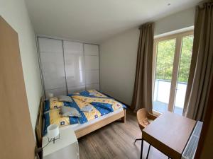 Schlafzimmer mit einem Bett, einem Tisch und einem Schreibtisch in der Unterkunft Apartmány Veternica v Bernarde in Nový Smokovec