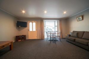 a living room with a couch and a table and chairs at Coronation Park Motels in Ashburton