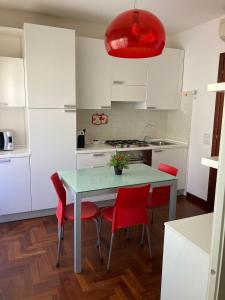 een keuken met een tafel en vier rode stoelen bij Da Sofia apartment-parking in Cagliari