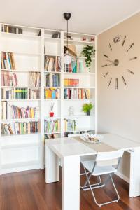 un comedor blanco con una mesa blanca y un reloj en Rosselli 13 Milan Apartment, en Milán