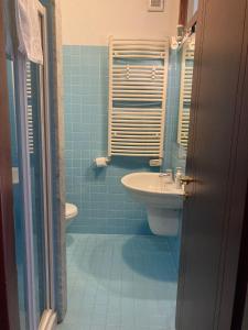 een blauwe badkamer met een wastafel en een toilet bij Da Sofia apartment-parking in Cagliari +18 foto's