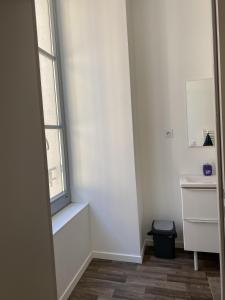 a small white room with a window and a desk at Villa des Thermes - T2 in Royat +4 photos