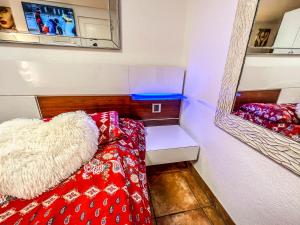 a small room with a bed and a mirror at Studio romantique vue sur camping in Saxon