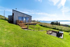 a house on top of a hill with a bench at Byre 7 Aird of Sleat in Aird of Sleat