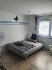 - une chambre dotée d'un lit avec un papillon sur le mur dans l'établissement Ella's Wolke Appartements - EW3, à Zweibrücken