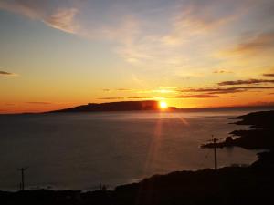 a sunset over the ocean with the sun in the sky at Byre 7 Aird of Sleat in Aird of Sleat