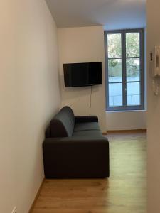 uma sala de estar com um sofá e uma televisão de ecrã plano em Villa des Thermes - T2 em Royat