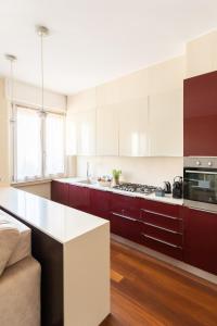 a kitchen with white cabinets and a white counter top at Rosselli 13 Milan Apartment in Milan
