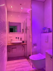a pink bathroom with a toilet and a sink at "Blue Sun" Apartament 11B HorizonPark Dziwnòwek in Dziwnówek