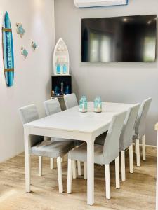 a white dining room table with chairs and a tv at "Blue Sun" Apartament 11B HorizonPark Dziwnòwek in Dziwnówek