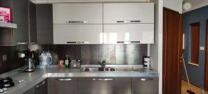 a kitchen with a sink and white cabinets at Velleran Apartment in Fgura