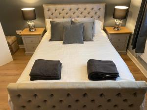 a large bed with two towels on top of it at Pendle House Apartment 1 in Colwyn Bay