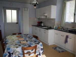 uma cozinha com uma mesa com uma toalha de mesa em CHEZ GRAND MAMIE em Polignac