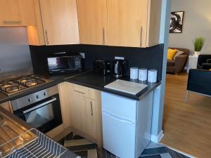 una cocina con encimera y estufa horno superior en Pendle House Apartment 1, en Colwyn Bay