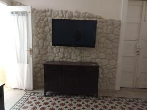 un soggiorno con TV su un muro di pietra di Casa vacanze home cecilie a Reggio di Calabria
