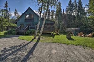 a green house with a tree in front of it at Charming Lake Placid Chalet with Deck and Forest Views in Lake Placid