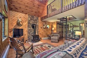 a living room with a staircase and a fireplace at Charming Lake Placid Chalet with Deck and Forest Views in Lake Placid