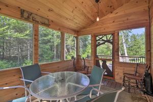 a dining room with a table and chairs in a cabin at Charming Lake Placid Chalet with Deck and Forest Views in Lake Placid