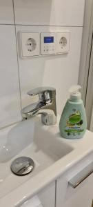 a bathroom sink with a bottle of detergent on it at The Modern Cave Lodge - ComfyHome Apartments Stuttgart in Stuttgart +48 photos