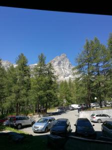 a parking lot with cars parked in front of a mountain at Grazioso monolocale vista Cervino in Breuil-Cervinia