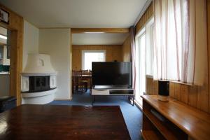 een woonkamer met een flatscreen-tv en een tafel bij Cosy House Strangata in Måsøy