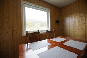 een eetkamer met een tafel en een raam bij Cosy House Strangata in Måsøy