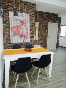 einen weißen Tisch mit Stühlen in einem Zimmer mit Gemälde in der Unterkunft TOP 3 Apartments in Strumica