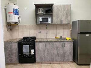 a kitchen with a stove and a microwave at Complejo Las Moras in Santa Rosa