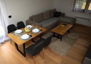 ズラティボールにあるApartman na brduのテーブル2つとソファのあるリビングルーム +11枚の写真