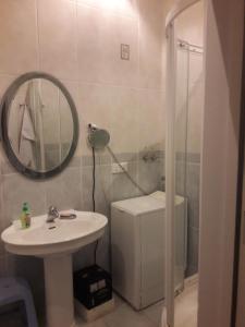 een badkamer met een wastafel, een spiegel en een douche bij NIZAMI Street 1 Bedroom in Baku
