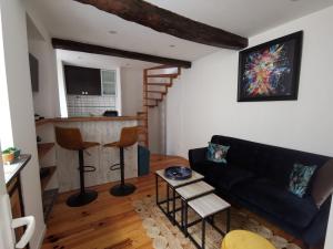 a living room with a black couch and a kitchen at Fourdray in Cherbourg en Cotentin