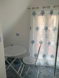einen Tisch und Stühle in einem Zimmer mit Fenster in der Unterkunft NERONE HOUSE in Diamante